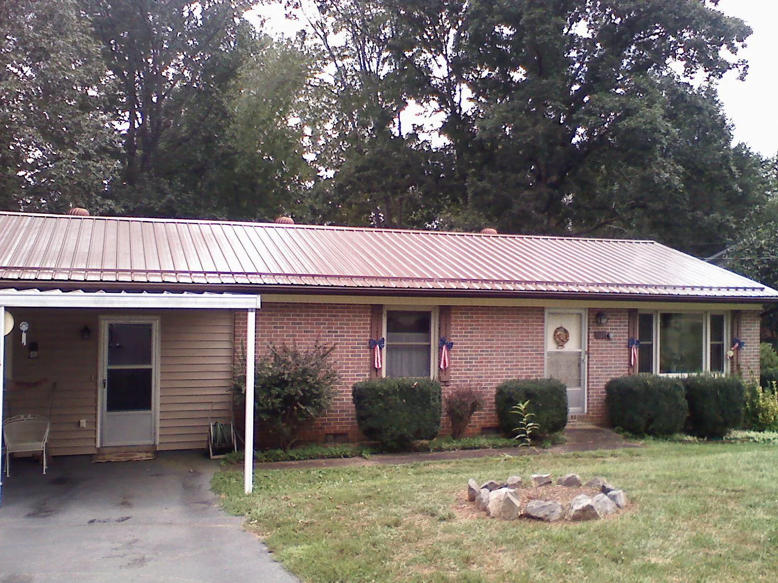 Bronze metal roof and carport on a brick ranch home — Roof Repair work by our crew in Bradley